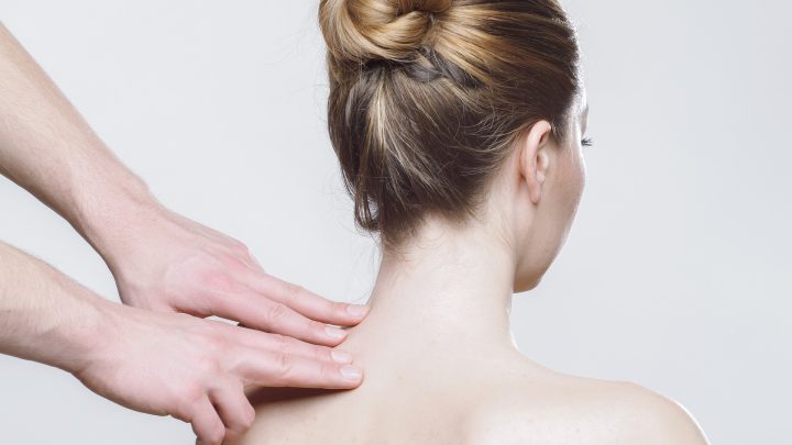 Eine Frau erhält Physiotherapie zur Linderung von Nackenverspannung. Professionelle Handgriffe zur Entspannung der verspannten Nackenmuskulatur.