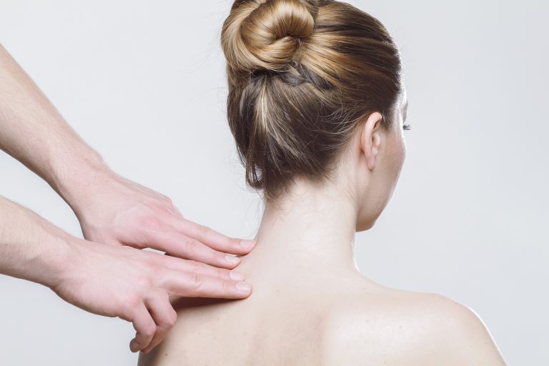 Eine Frau erhält Physiotherapie zur Linderung von Nackenverspannung. Professionelle Handgriffe zur Entspannung der verspannten Nackenmuskulatur.