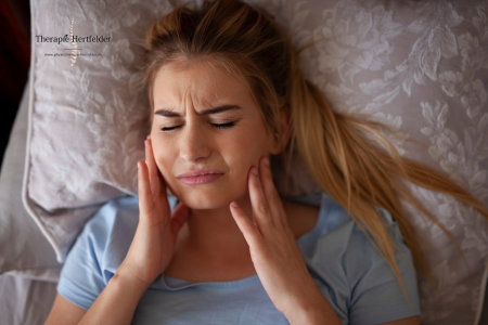 frau liegt im bett mit kieferschmerzen