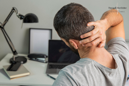 mann am arbeitsplatz mit nackenschmerzen